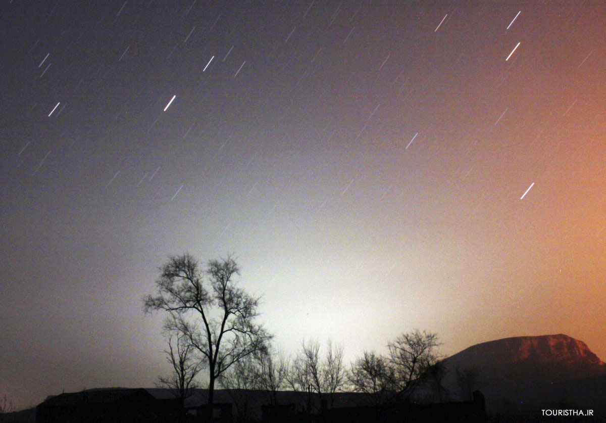a-long-exposure-photo-shows-star-trails-behind-a-tree-in-china